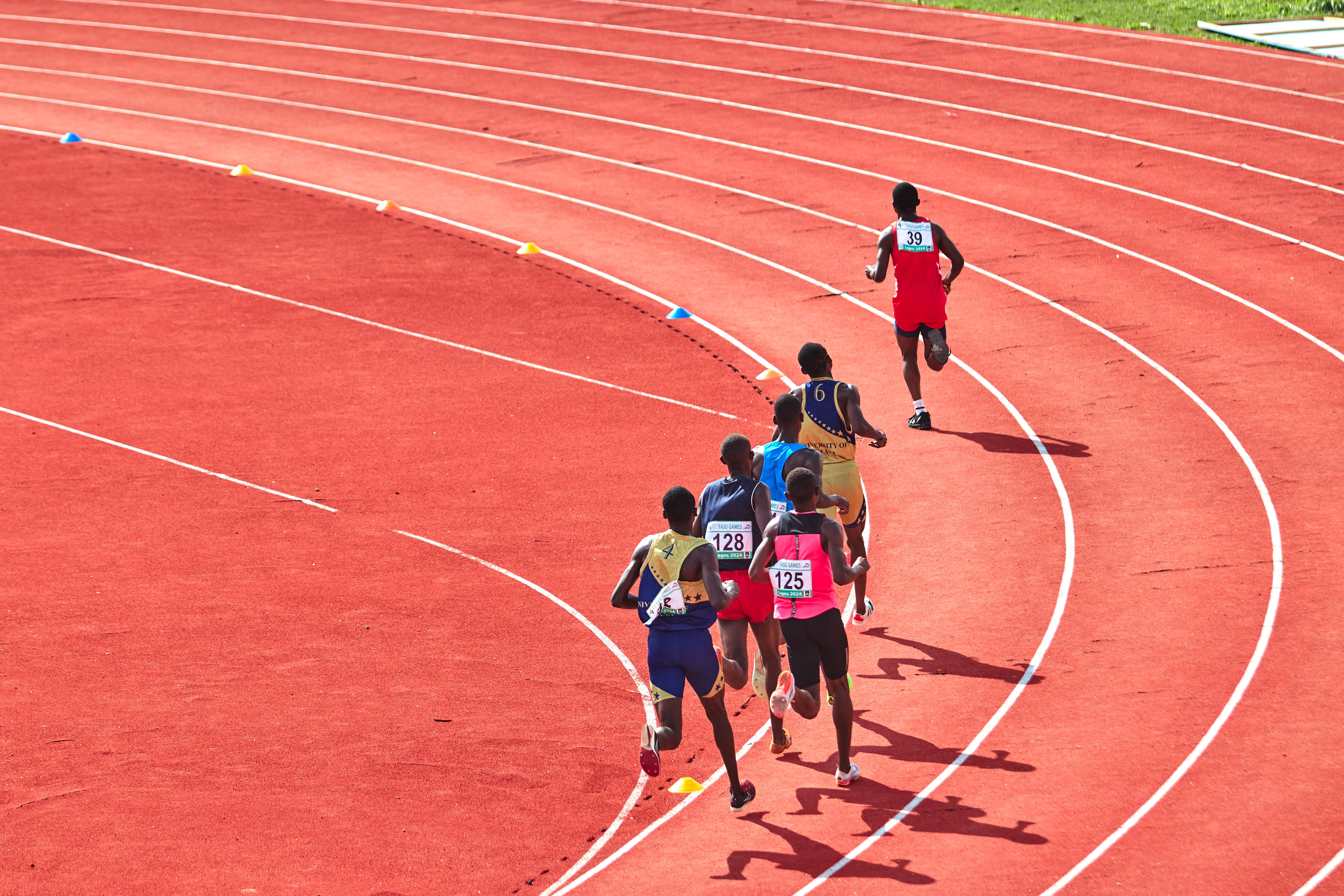 Competitive runners rounding the track curve